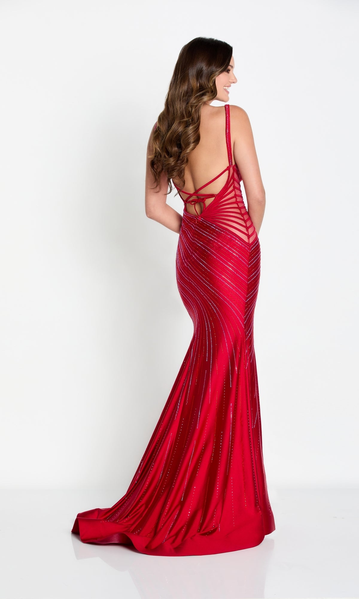 Woman wearing the Ellie Wilde Long Formal Gown with Striped Beading, featuring an open back and crisscross straps, standing against a plain white background.